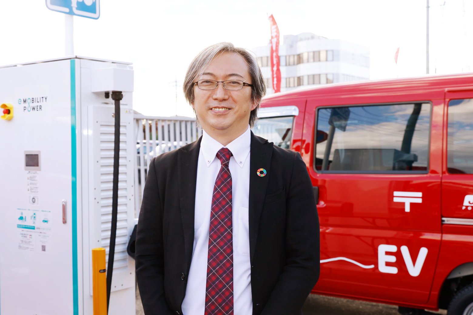 急速充電器の前に立つ内田さん